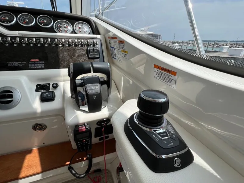 Slide: The Image of 2019 Sea Ray Sundancer 350 Coupe helm with controls and gauges. - 14