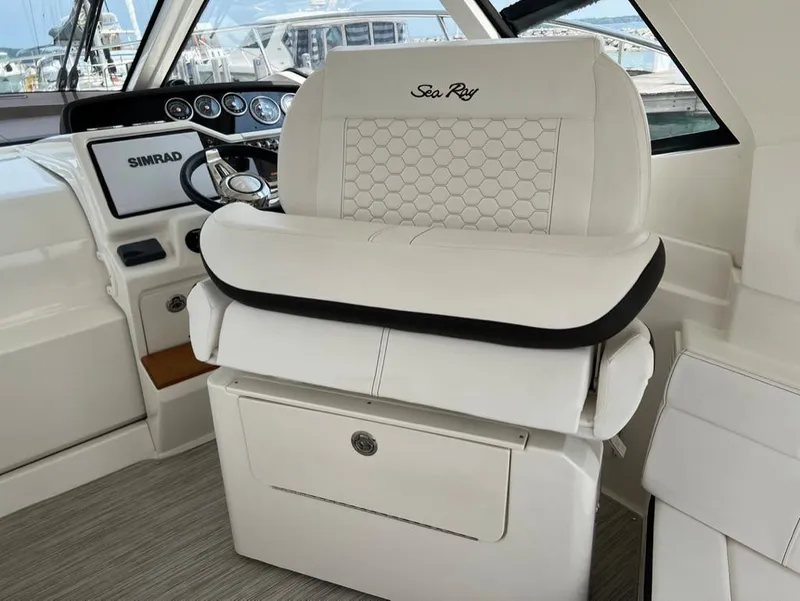 Slide: The Image of 2019 Sea Ray Sundancer 350 Coupe helm with white leather seating and Simrad navigation system. - 19