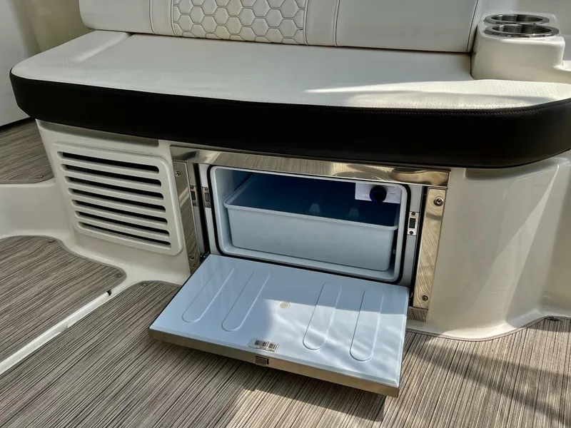 Slide: The Image of 2019 Sea Ray Sundancer 350 Coupe interior with open mini fridge and seating area. - 22