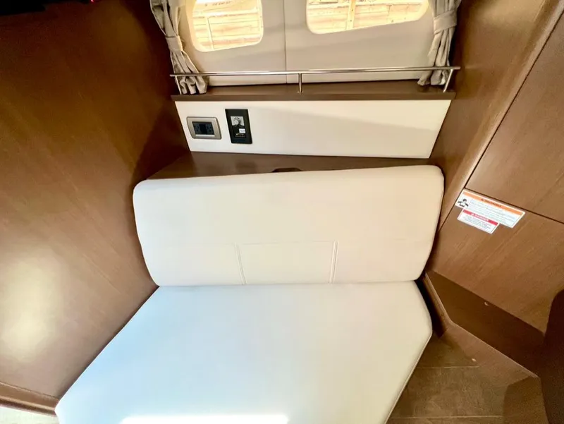 Slide: The Image of 2019 Sea Ray Sundancer 350 Coupe interior with beige seating and wooden accents. - 35