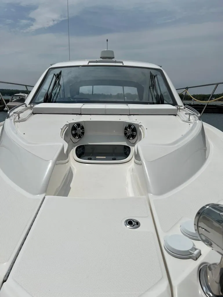 Slide: The Image of 2019 Sea Ray Sundancer 350 Coupe, sleek white exterior, docked under a cloudy sky. - 5