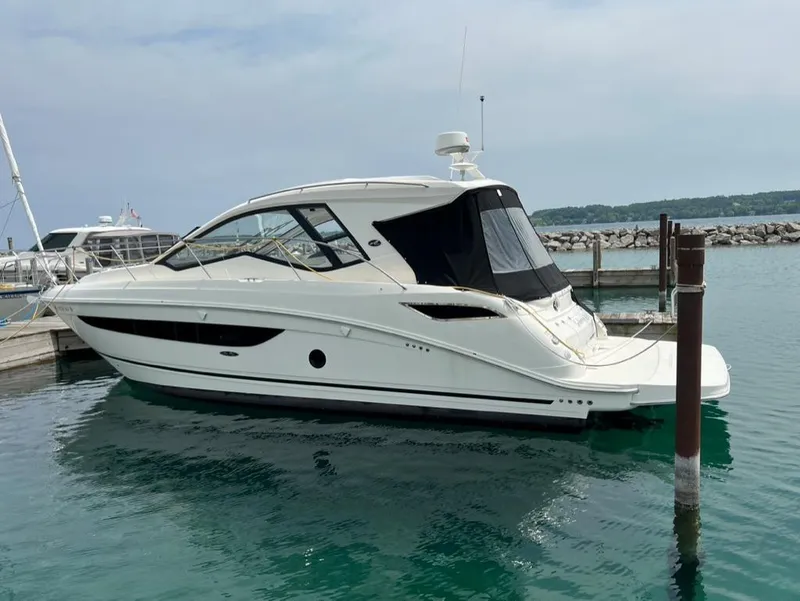 Slide: The Image of 2019 Sea Ray Sundancer 350 Coupe docked in a marina, calm water, clear sky. - 6
