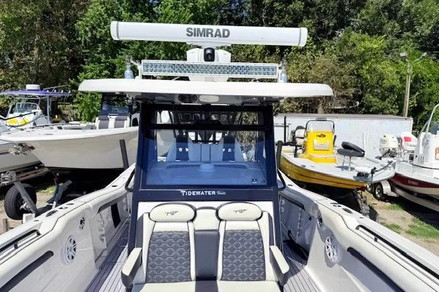 Slide: The Image of 2023 Tidewater 320 CC Adventure boat with Simrad electronics, docked among other vessels. - 14