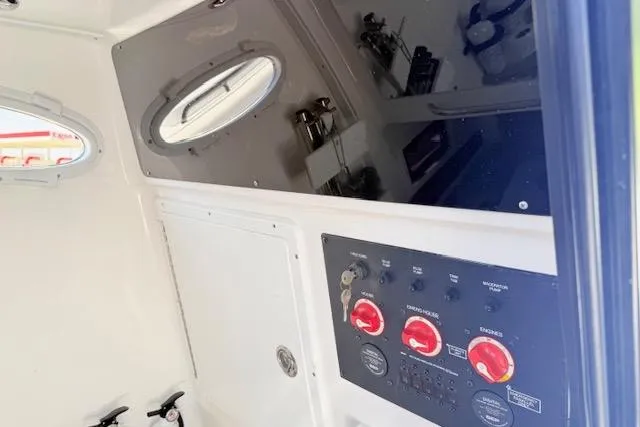 Slide: The Image of 2023 Tidewater 320 CC Adventure boat interior with control panel and porthole window. - 17