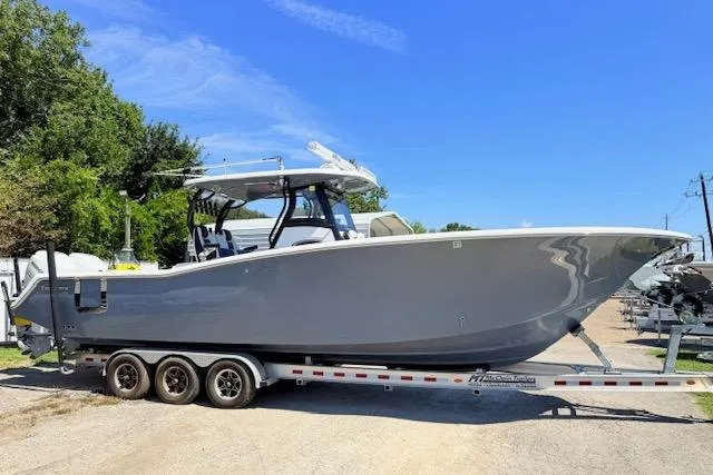 Slide: The Image of 2023 Tidewater 320 CC Adventure boat on a trailer, parked outdoors. - 3
