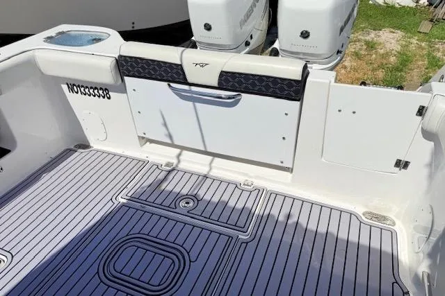 Slide: The Image of 2023 Tidewater 320 CC Adventure boat deck with twin engines and seating. - 4