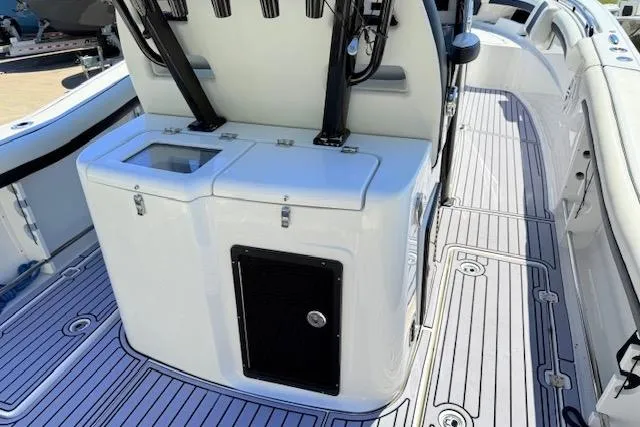 Slide: The Image of 2023 Tidewater 320 CC Adventure boat interior with sleek white deck and storage compartments. - 6