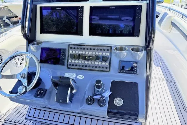 Slide: The Image of Control panel of 2023 Tidewater 320 CC Adventure boat with dual screens and steering wheel. - 8