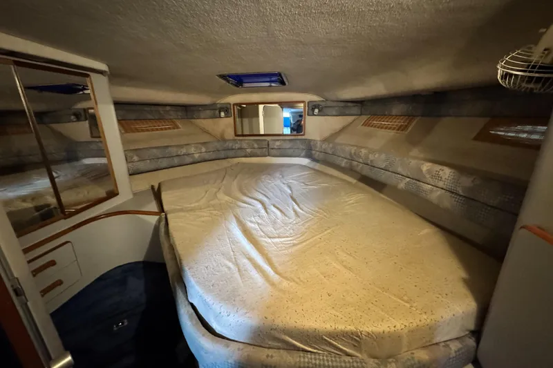 Slide: The Image of 1990 Sea Ray 350 Express Cruiser cabin with bed, mirror, and storage. - 10