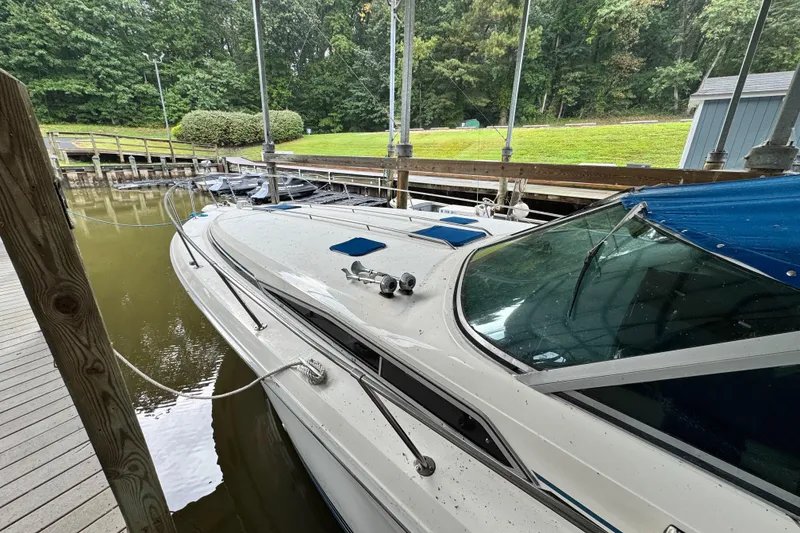 Slide: The Image of 1990 Sea Ray 350 Express Cruiser docked in a marina, surrounded by lush greenery. - 2