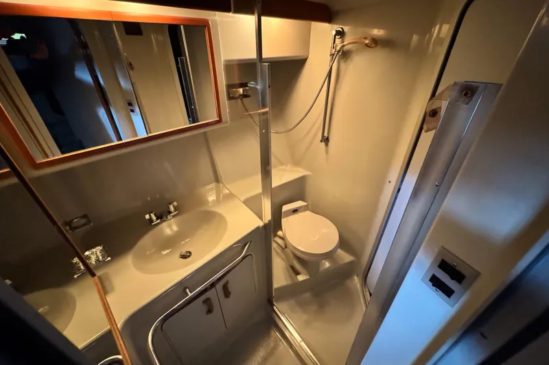 Slide: The Image of Bathroom interior of 1990 Sea Ray 350 Express Cruiser with sink, toilet, and shower. - 8