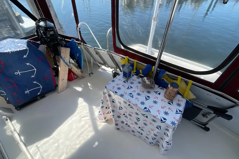 Slide: The Image of 1989 Jefferson 37 Sundeck boat with red trim and clear panels, docked outdoors. - 11