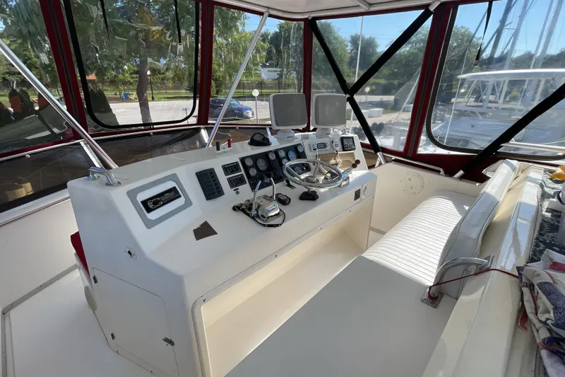 Slide: The Image of 1989 Jefferson 37 Sundeck with inflatable dinghy attached, docked on calm water. - 13