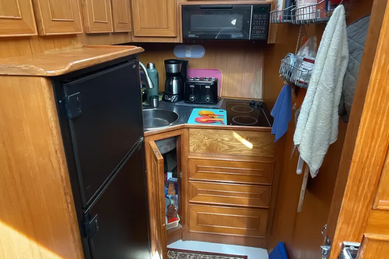 Slide: The Image of Compact kitchen in 1989 Jefferson 37 Sundeck boat with wooden cabinets and modern appliances. - 35
