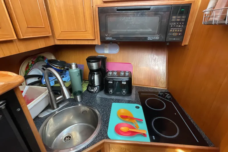 Slide: The Image of 1989 Jefferson 37 Sundeck kitchen with black fridge, wooden cabinets, and countertop appliances. - 38