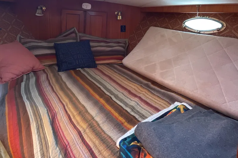 Slide: The Image of Cozy cabin interior of 1989 Jefferson 37 Sundeck with striped bedding and wooden cabinetry. - 40