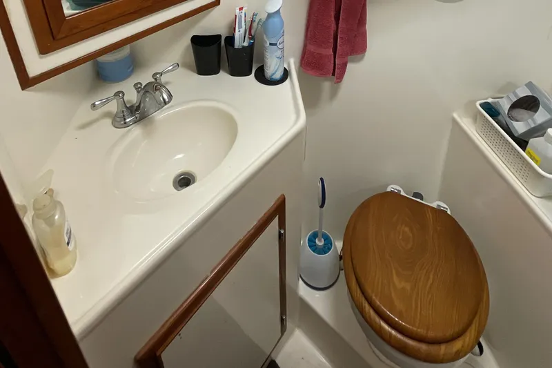 Slide: The Image of Bathroom interior of 1989 Jefferson 37 Sundeck yacht with sink and wooden toilet seat. - 52