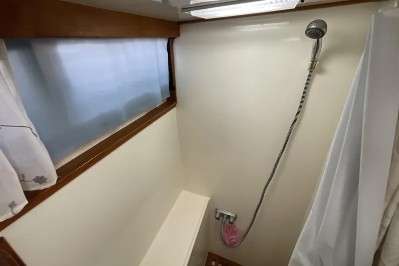 Slide: The Image of 1989 Jefferson 37 Sundeck boat shower with handheld showerhead and window. - 53