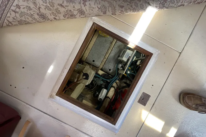 Slide: The Image of Access hatch on 1989 Jefferson 37 Sundeck boat, revealing internal components and wiring. - 54