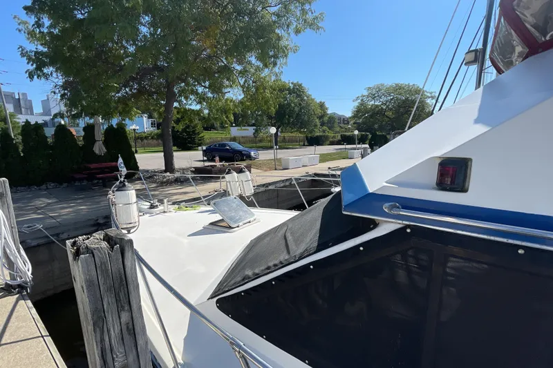 Slide: The Image of 1989 Jefferson 37 Sundeck yacht docked at marina under clear blue sky. - 6