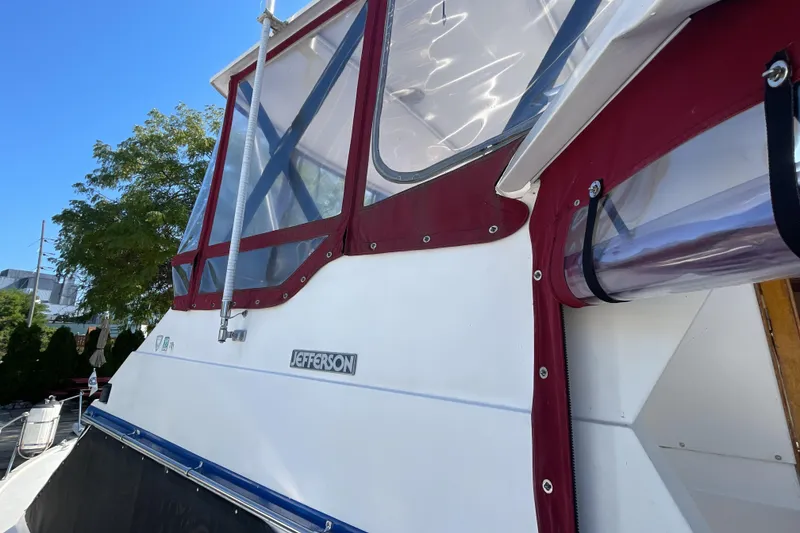 Slide: The Image of 1989 Jefferson 37 Sundeck yacht docked at marina under clear blue sky. - 7