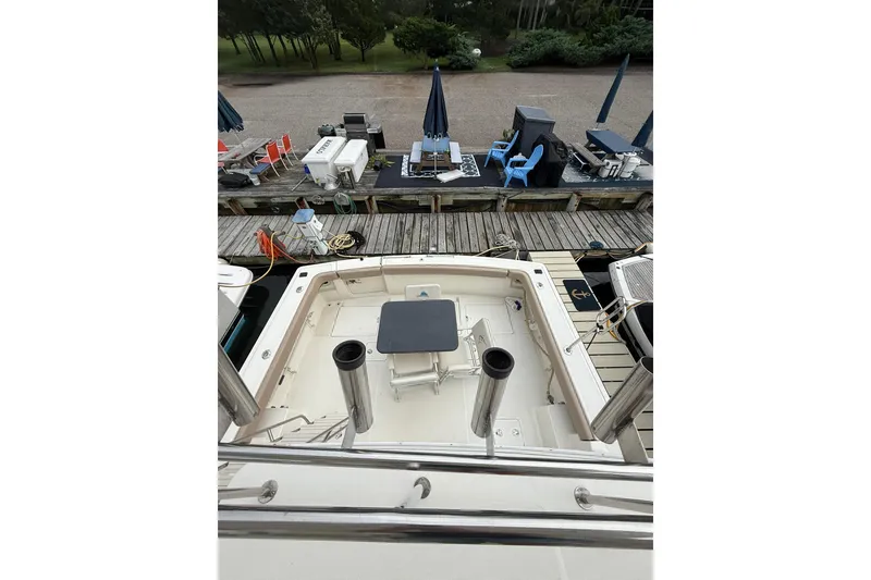 Slide: The Image of 1991 Tiara Yachts 4300 Convertible at dock, featuring spacious deck and seating area. - 11