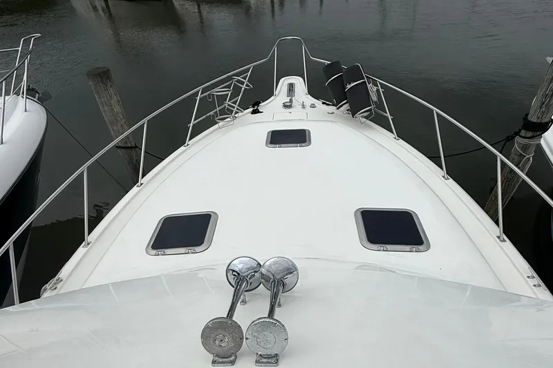 Slide: The Image of 1991 Tiara Yachts 4300 Convertible boat deck with hatches and railing in marina. - 13