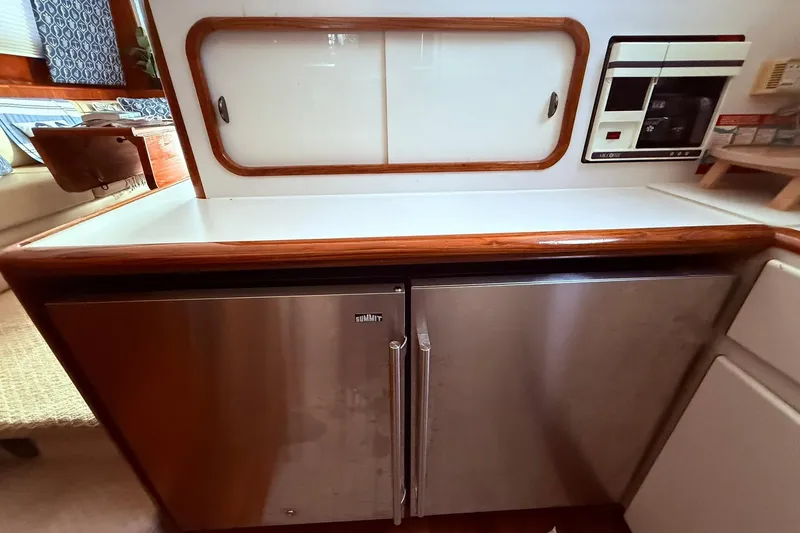 Slide: The Image of 1991 Tiara Yachts 4300 Convertible kitchen with stainless steel Summit refrigerator and wooden accents. - 16