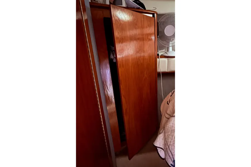 Slide: The Image of Wooden interior of 1991 Tiara Yachts 4300 Convertible with fan and open cabinet. - 19