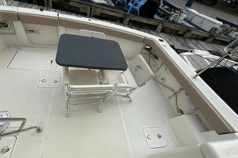Slide: The Image of 1991 Tiara Yachts 4300 Convertible deck with table and chairs, docked at marina. - 2