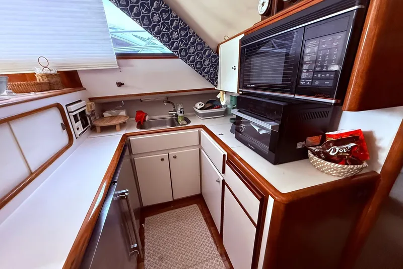 Slide: The Image of 1991 Tiara Yachts 4300 Convertible kitchen with modern appliances and wood accents. - 37