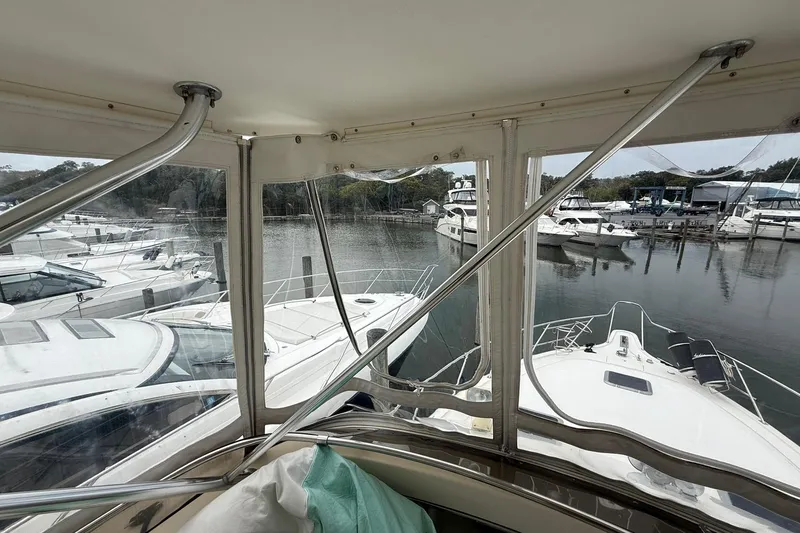 Slide: The Image of 1991 Tiara Yachts 4300 Convertible docked among other boats in a marina. - 46