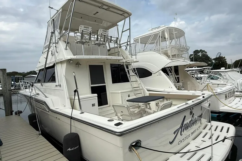 Slide: The Image of 1991 Tiara Yachts 4300 Convertible docked, featuring spacious deck and flybridge. - 47