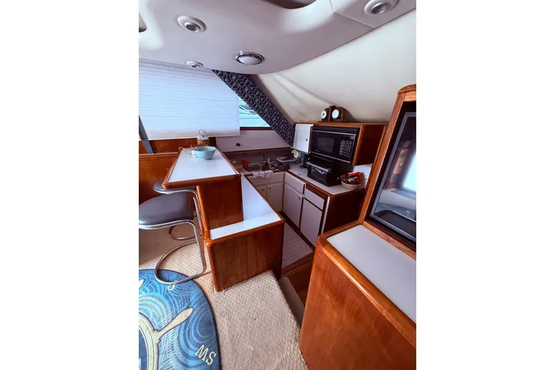 Slide: The Image of Interior of 1991 Tiara Yachts 4300 Convertible, featuring a compact kitchen and seating area. - 50