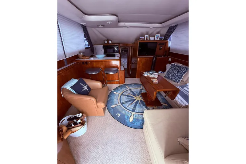 Slide: The Image of Luxurious interior of a 1991 Tiara Yachts 4300 Convertible with cozy seating and nautical decor. - 51