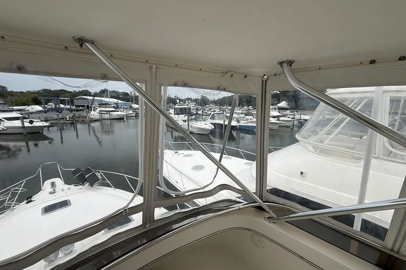 Slide: The Image of 1991 Tiara Yachts 4300 Convertible view from cabin, overlooking marina with docked boats. - 60