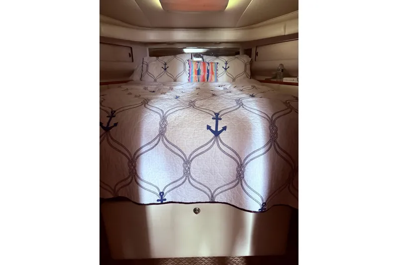 Slide: The Image of Nautical-themed bedroom in 1991 Tiara Yachts 4300 Convertible, featuring anchor-patterned bedding. - 63