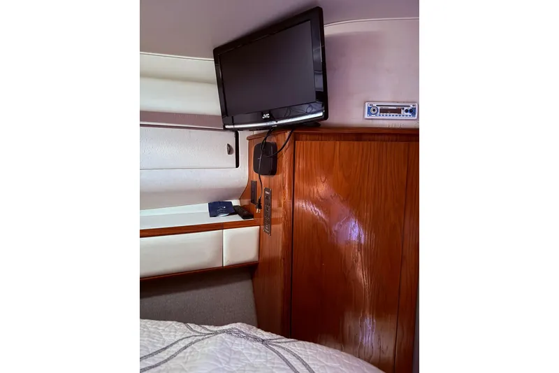 Slide: The Image of 1991 Tiara Yachts 4300 Convertible interior with TV and wooden cabinetry. - 65