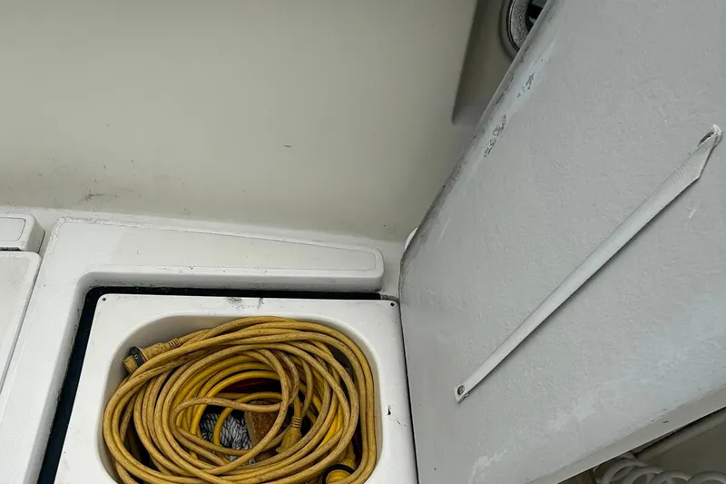 Slide: The Image of Storage compartment with yellow hose on 1991 Tiara Yachts 4300 Convertible. - 66
