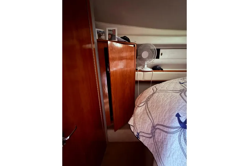 Slide: The Image of Interior of 1991 Tiara Yachts 4300 Convertible with wooden cabinetry and nautical-themed bedding. - 68