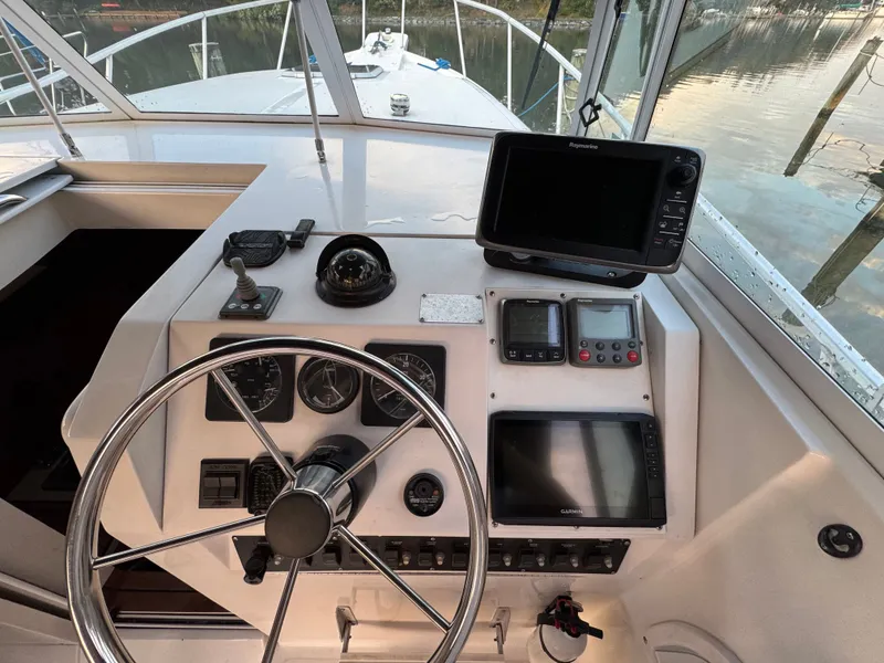 Slide: The Image of 1999 Mainship Pilot 30 Sedan helm with navigation equipment and steering wheel. - 13