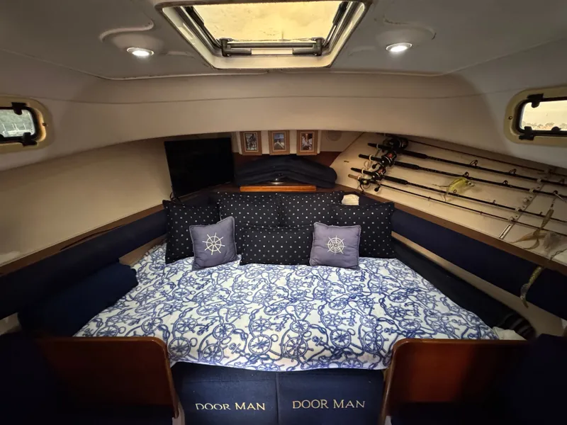 Slide: The Image of Cozy cabin interior of 1999 Mainship Pilot 30 Sedan with nautical decor and fishing rods. - 14