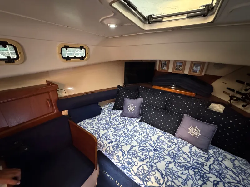Slide: The Image of 1999 Mainship Pilot 30 Sedan cabin interior with nautical-themed bedding and decor. - 16
