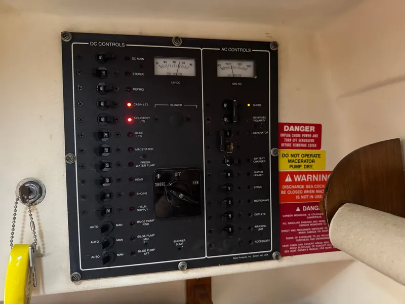 Slide: The Image of Electrical control panel on a 1999 Mainship Pilot 30 Sedan boat with warning labels. - 21