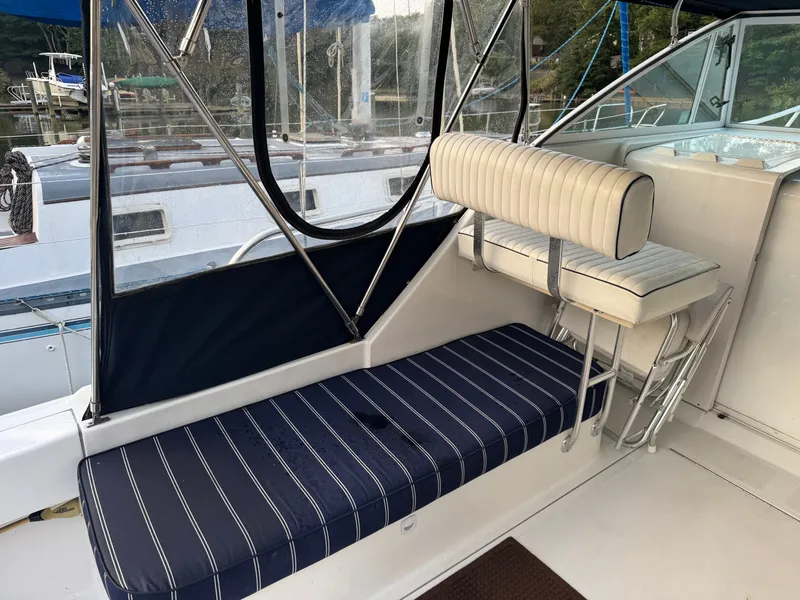 Slide: The Image of 1999 Mainship Pilot 30 Sedan interior with striped seating and clear enclosure. - 9