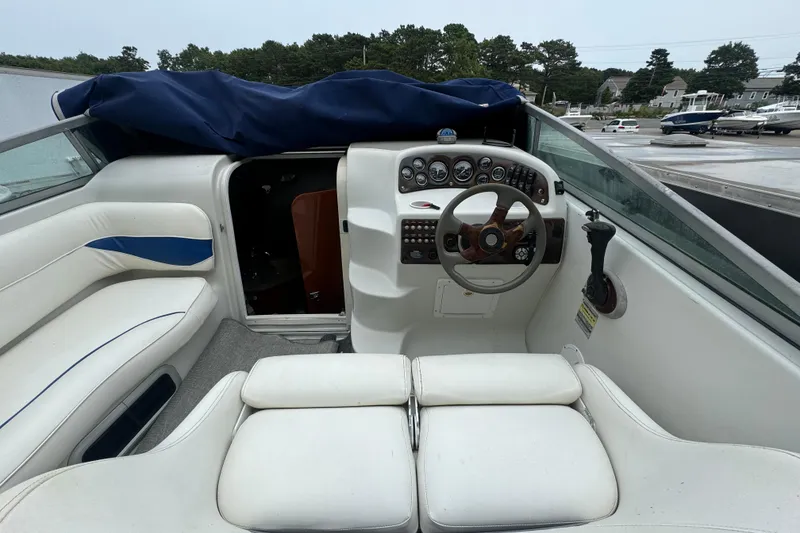 Slide: The Image of 2003 Crownline 266 BR boat interior with steering wheel and seating area. - 4