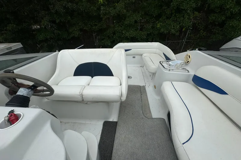 Slide: The Image of 2003 Crownline 266 BR boat interior with white seating and steering wheel. - 6