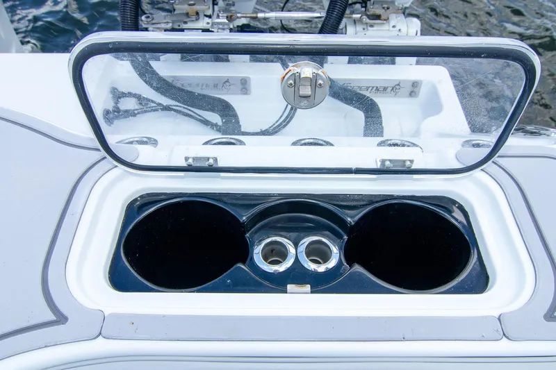 Slide: The Image of Open storage compartment on 2022 Freeman 37 VH boat, featuring cup holders and a transparent lid. - 41