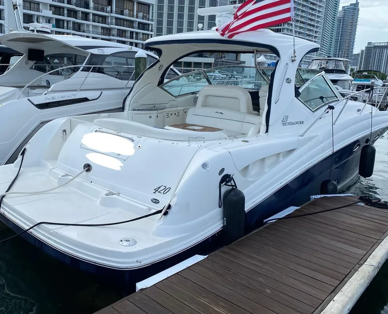 Slide: The Image of 2005 Sea Ray 420 Sundancer yacht docked at marina with American flag. - 15