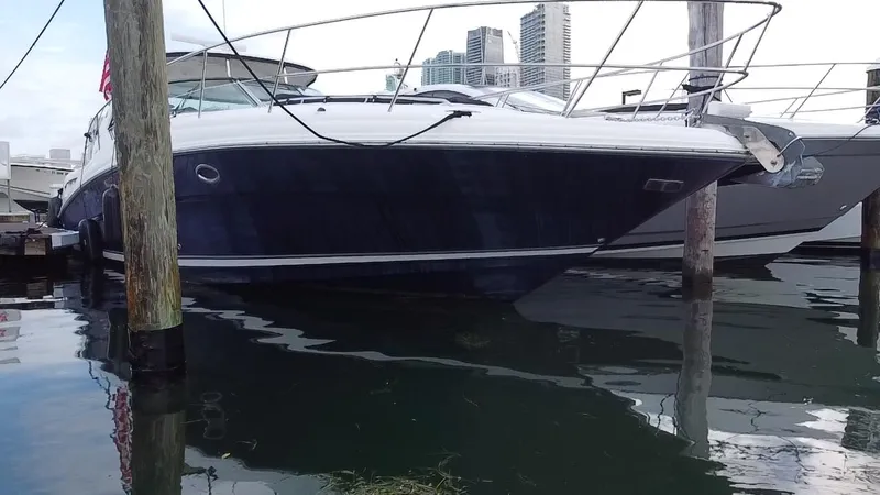 Slide: The Image of 2005 Sea Ray 420 Sundancer yacht docked at marina with city skyline in background. - 5